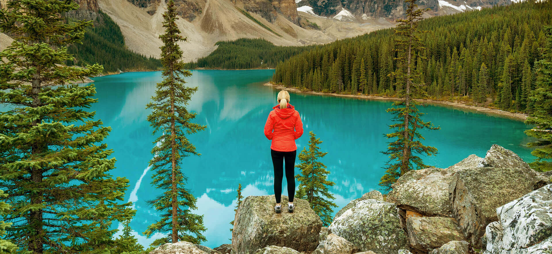 Woman on rock in front of lake