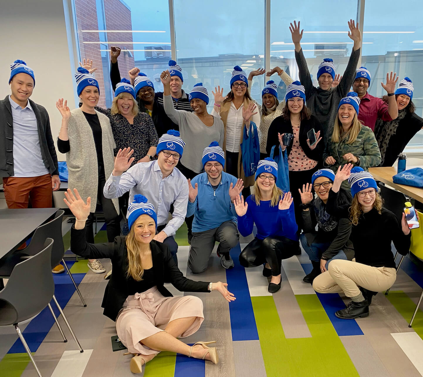 Group of people smiling wearing Bell Let's talk beanies