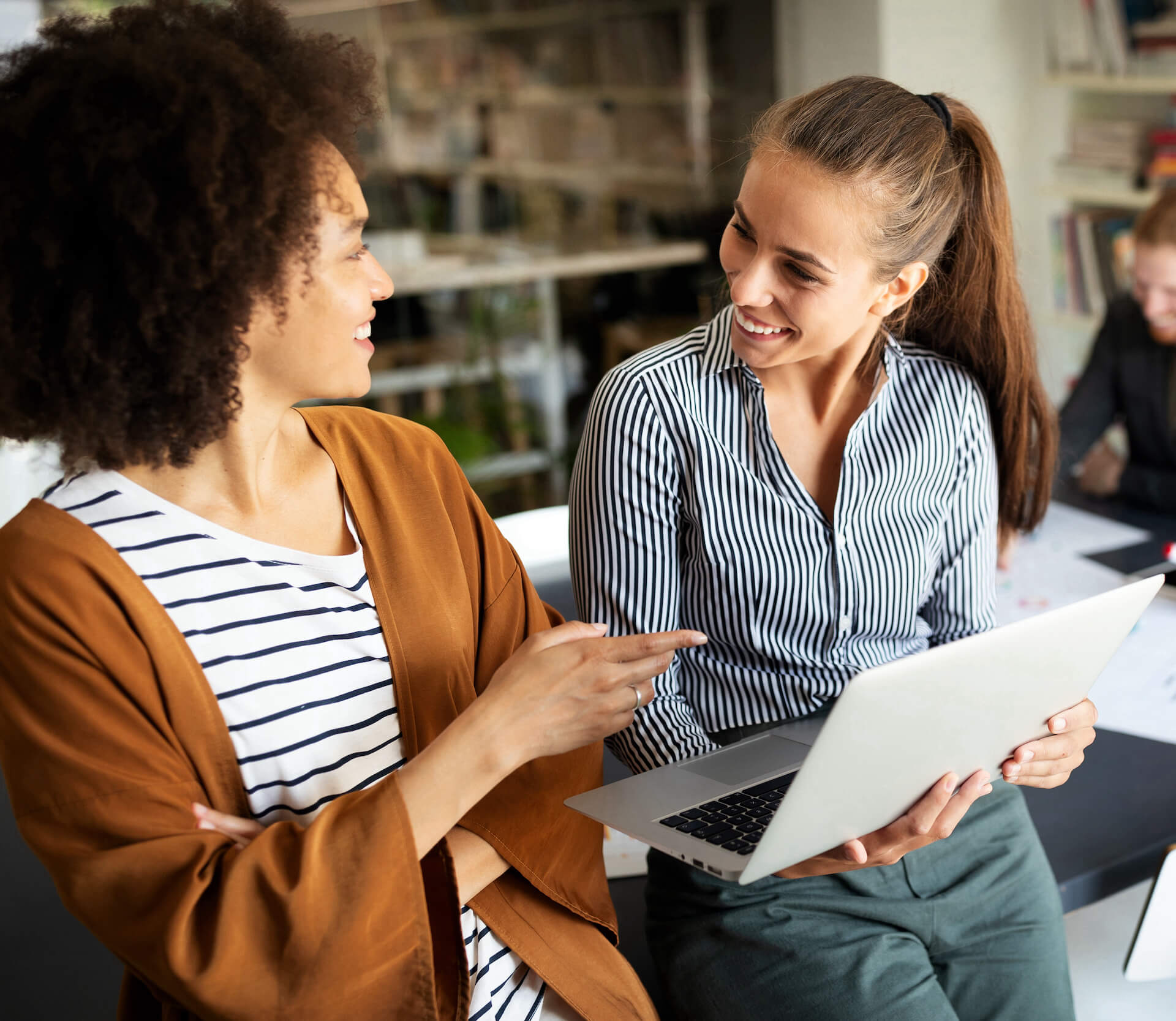 Two women smiling with laptop