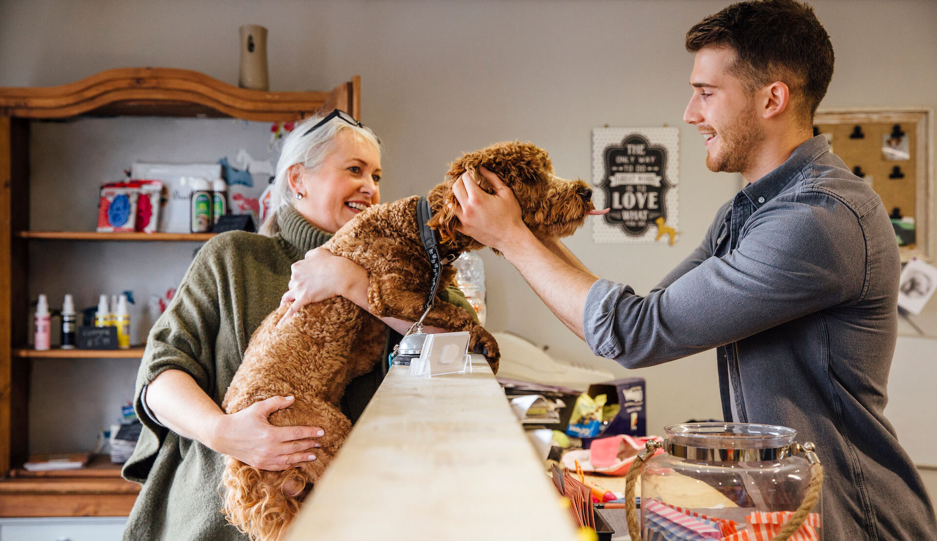 Woman holding dog and man petting the dog